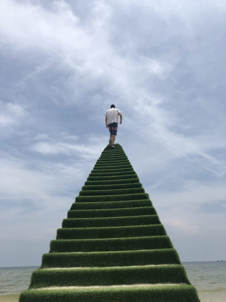 Cory Althoff walking up stairs over water.